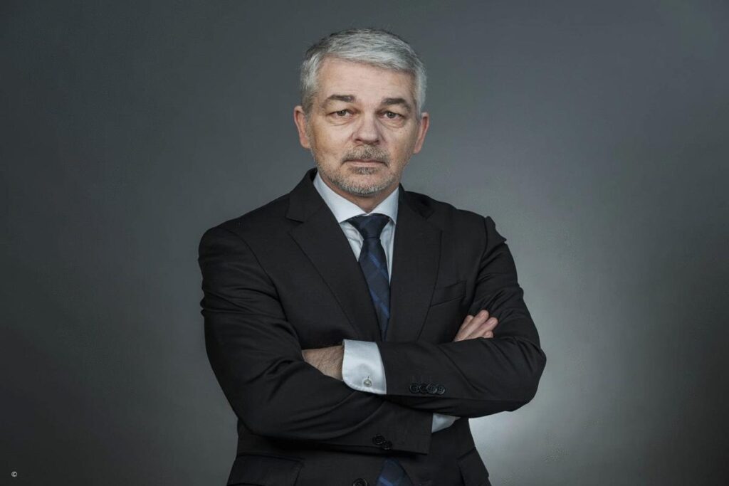 Mit wem ist Carlo Masala verheiratet? Carlo Masala im Anzug mit verschränkten Armen vor neutralem Hintergrund – Experte für internationale Politik