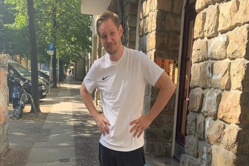 Falko Ochsenknecht lächelnd auf einem Sofa sitzend, entspannter Porträtstil