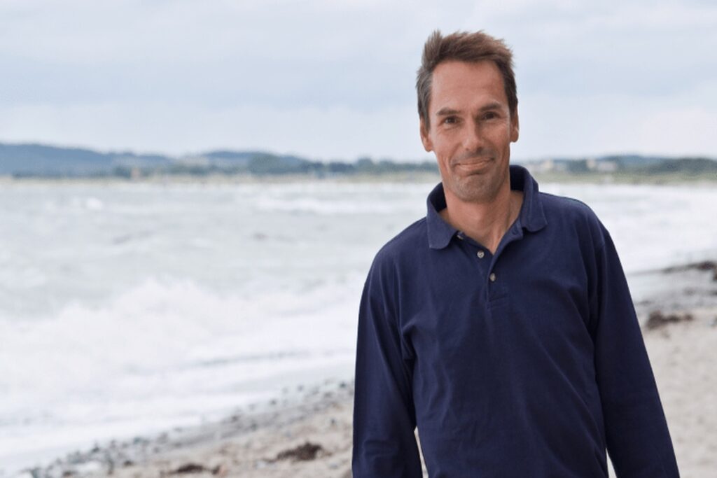 Meeno Schrader entspannt am Strand mit Blick aufs Meer